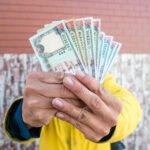 Man showing a handfull of Nepalese money