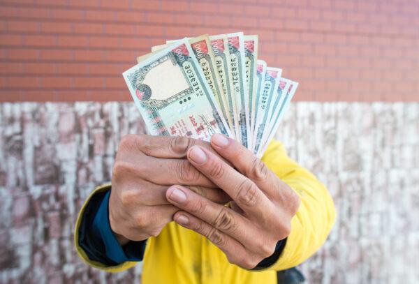 Man showing a handfull of Nepalese money
