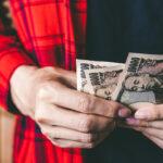 A man holding Japanese money