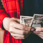 A man holding Japanese money