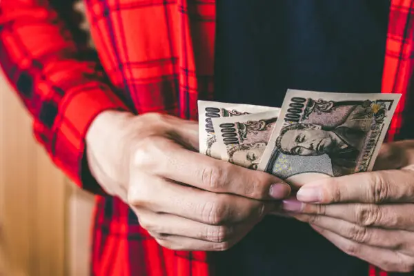 A man holding Japanese money